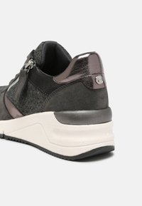 Šedé tenisky s texturovaným svrškem, kovovými akcenty, polstrovanou podrážkou a zipovým detailem na boku, poskytujícímoderní design.