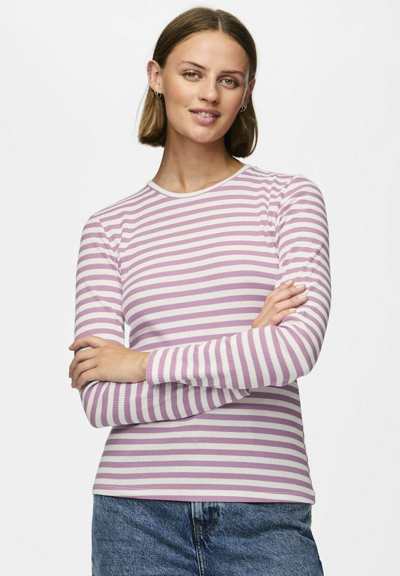 Ilgaausis viršus su horizontaliomis rožinėmis ir baltomis juostelėmis, su įribuota tekstūra ir apvaliu iškirpimu. Suderintas su mėlynomis džinsomis.