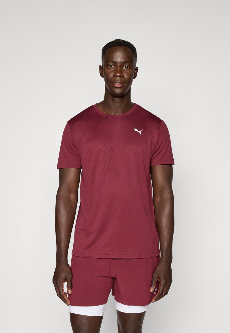 Bordeaux sportshirt met ronde hals en korte mouwen, voorzien van een klein wit logo op de borst, gecombineerd met bijpassende shorts.