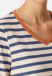 Randig bomull t-shirt med horisontella marinblå och beige ränder, V-krage med en kontrasterande orange kant, mjuk textur.
