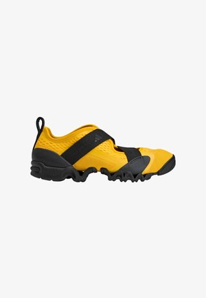 Yellow and black athletic shoes with a mesh upper, rubber sole, and elastic strap for a secure fit. Textured side for added grip.