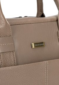 Beige Lederhandtasche mit strukturiertem Oberflächen, goldfarbener Logo-Plakette, doppelten Griffen und kontrastierenden Nähdetails.