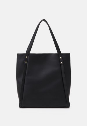 Black leather tote bag with two long handles and gold-tone rivet details on a plain light background.