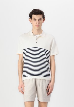 Short-sleeve polo shirt in cream with navy horizontal stripes, featuring a collar and three-button placket, paired with light gray shorts.