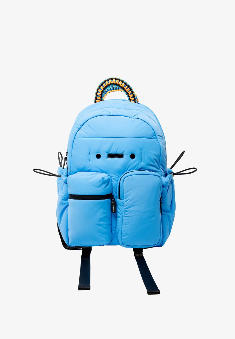 Sac à dos rembourré bleu clair avec une poignée supérieure tissée bien en vue, deux poches extérieures et des bretelles noires réglables.