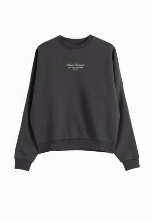 Dark gray crewneck sweatshirt with long sleeves, ribbed cuffs and hem, and small white text logo centered on the chest.