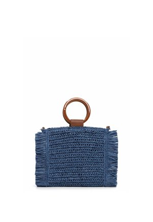 Blue woven handbag with fringed edges and a large round brown handle on top, set against a white background.