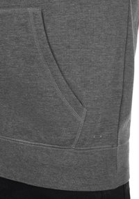 Grijze sweatshirt met een kangoeroezak, ribgebreide mouwen en zoom. Opvallende stikseldetails en een klein merklabel bij de zak.
