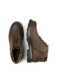 Bruine leren enkelboots met een gladde afwerking, vetersluiting, zijrits, rubberen zool en versterkte stikseldetails.