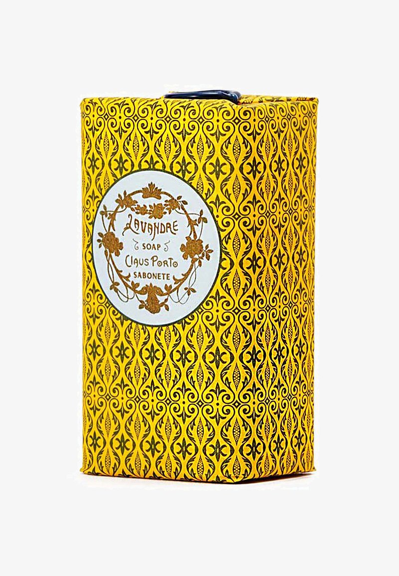 Die Verpackung der Lavendel-Seife präsentiert ein lebhaftes gelbes Design mit komplizierten schwarzen Mustern. Ein weißes Etikett zeigt den Produktnamen und die Marke.