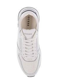 Zapatilla blanca con materiales de malla y cuero, puntera redondeada, diseño con cordones y marca "GUESS" en la lengüeta y en los acentos laterales.