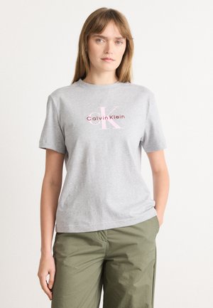 Grijze katoenen t-shirt met korte mouwen, voorzien van een roze en rode Calvin Klein-logo dat op de voorkant is gedrukt. Casual fit, eenvoudig ontwerp.