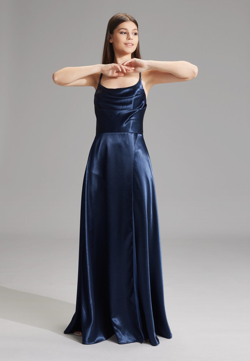 Abito da sera in raso blu navy con scollatura a manica a cappuccio, spalline sottili e gonna fluida con fessure laterali per movimento ed eleganza.