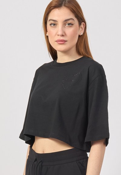 T-shirt nera cropped in cotone, con colletto rotondo e maniche corte. Presenta un piccolo logo discreto sul petto.