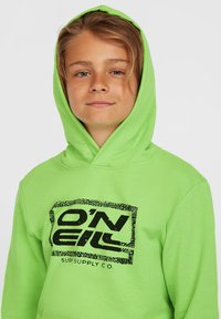 Sudadera verde con un logotipo gráfico negro que presenta "O'Neill Surf Supply Co." Tejido suave, bolsillo tipo canguro y capucha amplia.