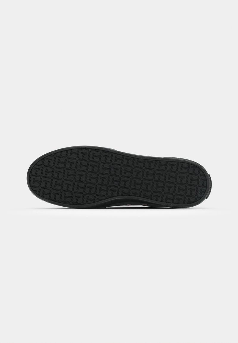 Semelle en caoutchouc noir avec un motif de grip texturé comportant des formes géométriques entrelacées. Bords propres et lisses sans défauts visibles.