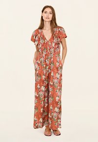 Bloemen jumpsuit in roestoranje, met korte mouwen, V-hals en voorzakken. Kenmerkt zich door een gestructureerde stof met levendige bloemenpatronen.