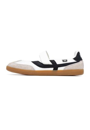 Zapato de tela blanca con una raya negra, una puntera beige texturizada y una suela de goma marrón. Cuenta con una correa de velcro para el cierre.