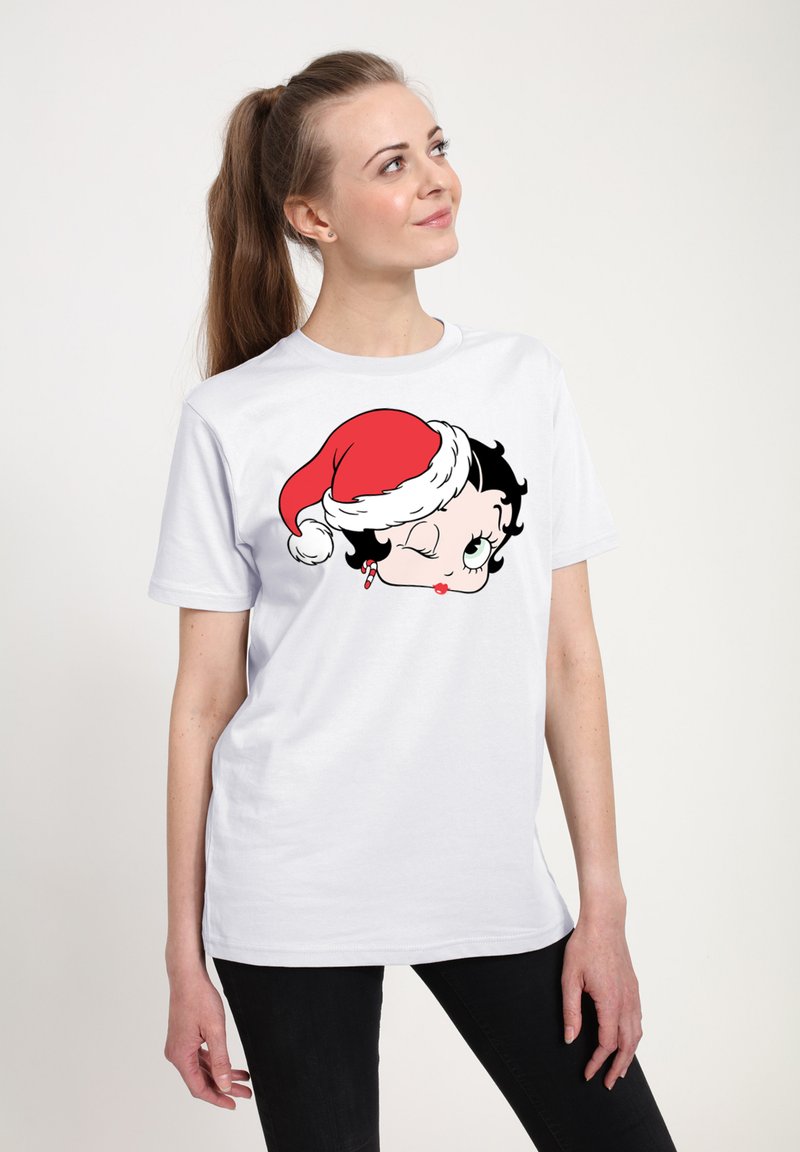 Hvid bomuld t-shirt med et grafisk motiv af en karakter, der blinker og bærer en rød nissehat, med sort hår og grønne øjne, trykt i sort og rød.