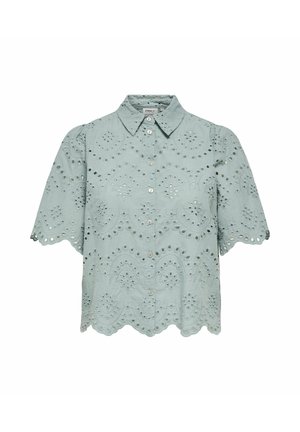 Šviesiai mėlyna trumpomis rankovėmis palaidinė su kiaurymėmis nėrinių raštu, banguotais kraštais, apykakle ir priekiniais sagomis užsegamais uždarymais.