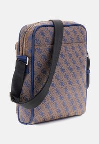 Braune gestreifte Tasche mit navy Akzenten, ausgestattet mit einem Reißverschluss, einem verstellbaren schwarzen Tragegurt und einer strukturierten rechteckigen Form.
