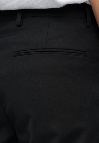 Μαύρο παντελόνι με λείο ύφασμα και κομψό σχέδιο, μια διακριτική πίσω τσέπη και ραφές κατά μήκος του ανοίγματος της τσέπης.