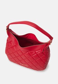 Sac à bandoulière en cuir rouge matelassé avec une fermeture éclair supérieure, des accents métalliques dorés, et une poignée unique pour le porter.