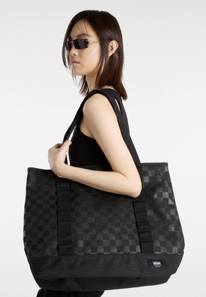 Czarna torba tote w kratkę, wykonana z trwałego materiału, z mocnymi paskami i naszywką z logo. Torba jest przestronna i ma gładką teksturę.