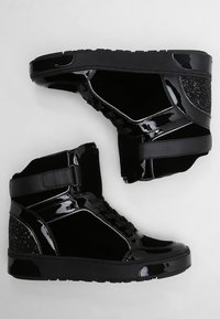 Černé sportovní vysoké tenisky vyrobené z lakované kůže a semiše, s texturovanými akcenty, šněrováním na přední straně a popruhem pro zvýšenou oporu.