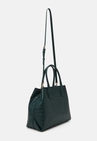 Tmavě zelená kožená kabelka s krokodýlím reliéfem, se dvěma horními držadly a odnímatelným popruhem. Má pevný tvar a zlaté kovové doplňky.