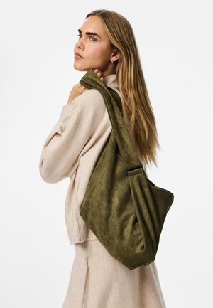 Olīvu zaļa zamša plecu soma ar brīvu dizainu, ar vienu siksniņu un priekšējo kabatu. Tekstūra ir mīksta un samtainā.