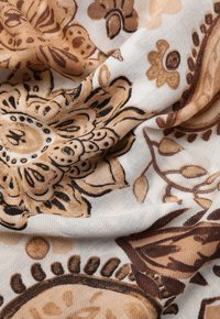 Tejido de algodón floral con un patrón en marrón y beige que presenta flores y hojas intrincadas, una textura suave y una caída fluida.