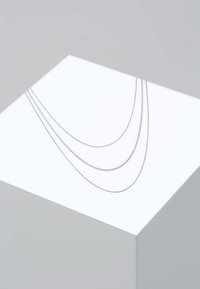 Collier en argent avec trois couches composées de chaînes aux designs variés : une chaîne délicate avec des perles, une chaîne en maillons lisses et une chaîne en maillons torsadés.