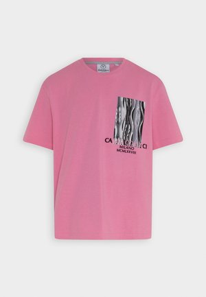 Różowa bawełniana koszulka z grafiką po lewej stronie z czarnymi i szarymi falistymi wzorami oraz napisem, okrągłym dekoltem i krótkimi rękawami.