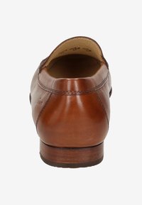 Bruine leren schoen met een ronde neus, een gladde textuur en minimale stikseldetails. De lage hak is van hout, wat zorgt voor een klassieke uitstraling.