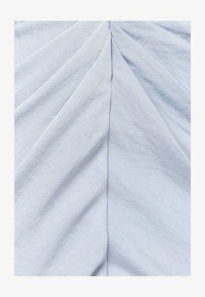 Svjetloplava tkanina s ušivenim središnjim šavom koji stvara simetrične dijagonalne nabore koji se šire prema van.