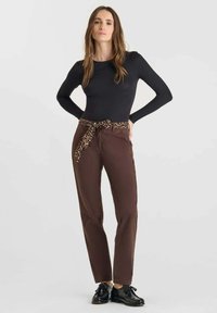 Pantaloni marroni con cintura a stampa leopardata, materiale in cotone, design a gamba dritta, abbinati a un top aderente a maniche lunghe nero e scarpe nere.