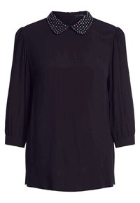 Blusa nera con maniche lunghe e colletto rotondo con borchie argentate, realizzata in tessuto morbido con una vestibilità ampia e maniche arricciate.