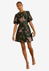 Rochie cu mânecă scurtă, de culoare neagră, cu broderie florală în nuanțe de roz și verde, având un decolteu tip cheie, mâneci evazate și un tiv evazat.