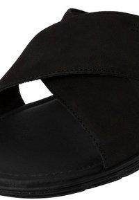 Sandalo in pelle nera con design incrociato, punta aperta e finitura texturizzata. Presenta una suola piatta e robusta per il massimo comfort.