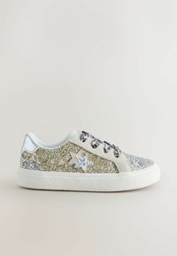 Zapatilla cubierta de purpurina con acentos en plata y oro, que presenta una superficie texturizada, diseños en forma de estrella y agujeros de cordones con patrones.
