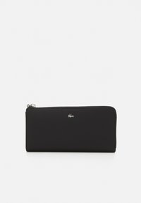 Portefeuille zippé noir en matériau texturé avec un détail en argent du logo Lacoste sur le devant, présentant une forme rectangulaire élégante.