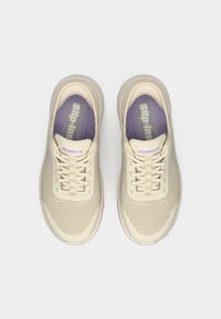 Μπεζ αθλητικά παπούτσια από δίχτυ με σχεδιασμό χωρίς κορδόνια, ελαφρύ κατασκευή και εμφανή κορδόνια. Μωβ εσωτερικές σόλες με λεπτομέρειες σήμανσης.
