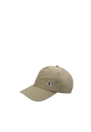 Gorra de béisbol beige con visera curva y pequeño emblema de calavera y huesos cruzados en blanco y negro en el panel frontal izquierdo.