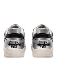 Sneakers in pelle argentata con dettagli neri, caratterizzati da una finitura testurizzata e dal logo nero "diadora 1990" sul tallone.