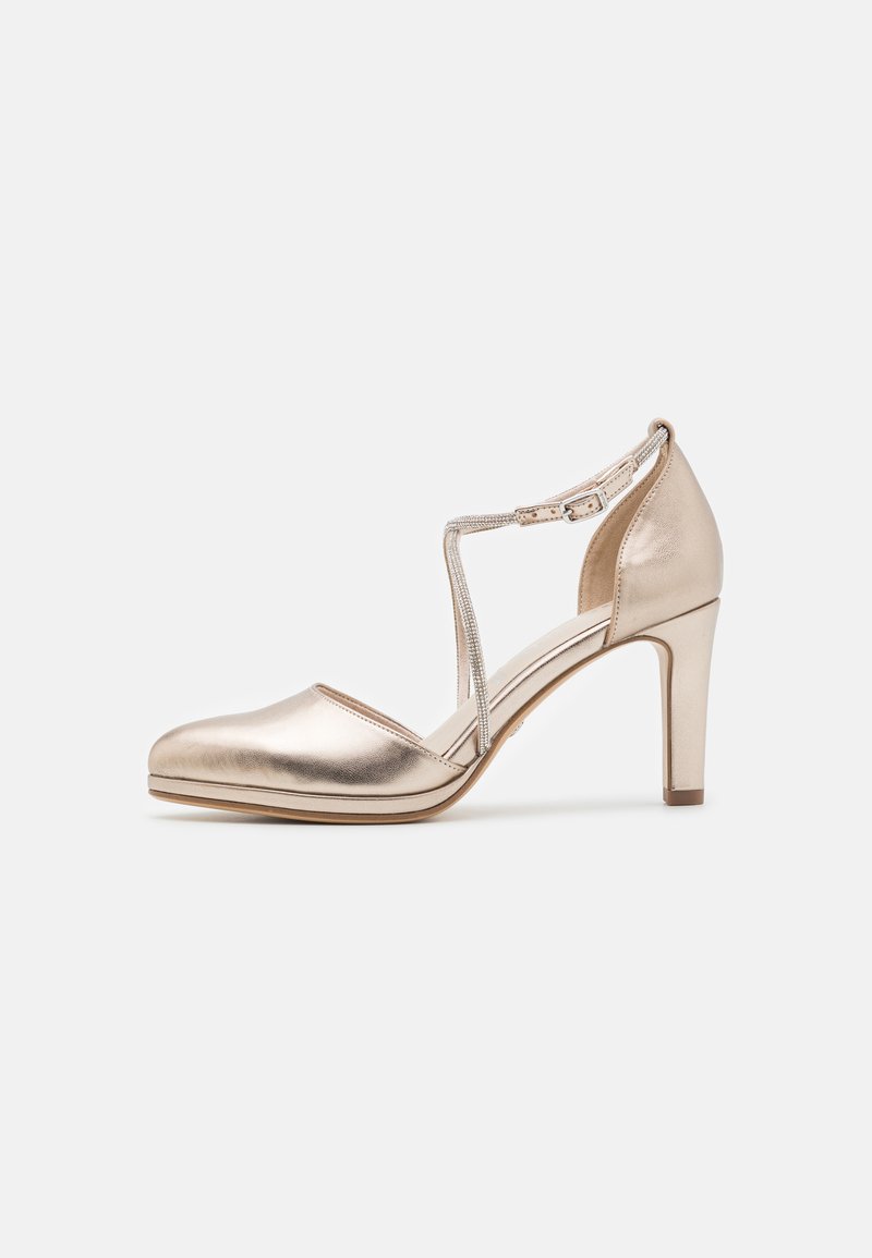 Chaussure à talons hauts en métal doré avec un bout arrondi, design à bride T et une texture lisse. Dotée d'un talon fin et d'une plateforme discrète.