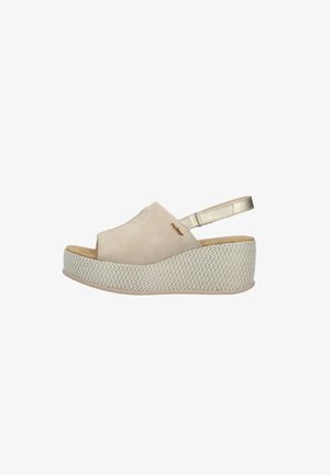 Beige wedge sandal with textured platform sole, closed toe upper, and adjustable metallic back strap.