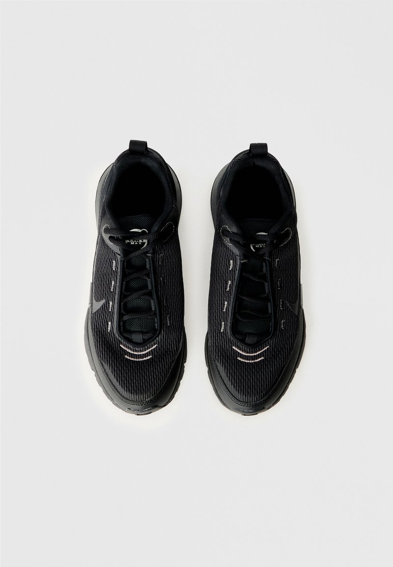 Zapatillas negras con una parte superior de tela texturizada, diseño de cordones elásticos y suela de goma. Cuenta con sutiles acentos reflectantes para mayor visibilidad.