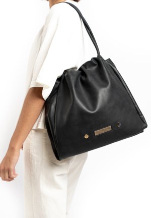 Sac fourre-tout en cuir noir avec un haut froncé, des accents en métal doré et un panneau texturé à l'avant. Surface lisse avec un drapé doux.