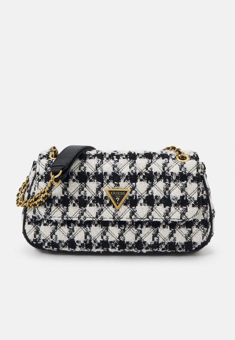 Sac à main en tissu à motif pied-de-poule noir et blanc avec bandoulière chaîne dorée et plaque logo Guess sur le rabat avant.